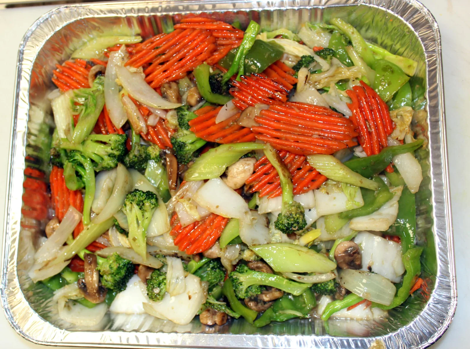 Catering tray of stir-fried prawns and vegetables