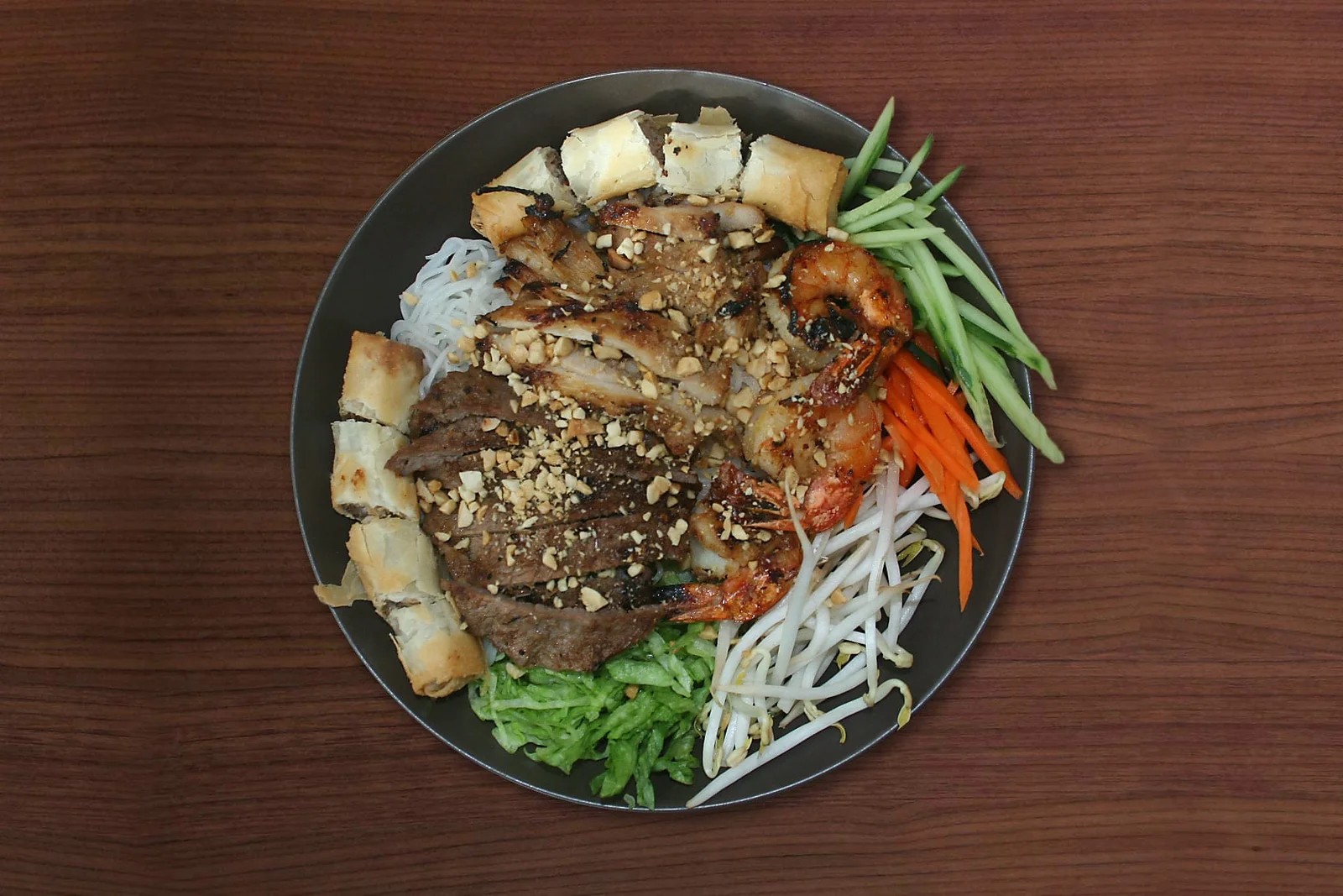 Grilled pork and prawns over vermicelli with crushed peanuts