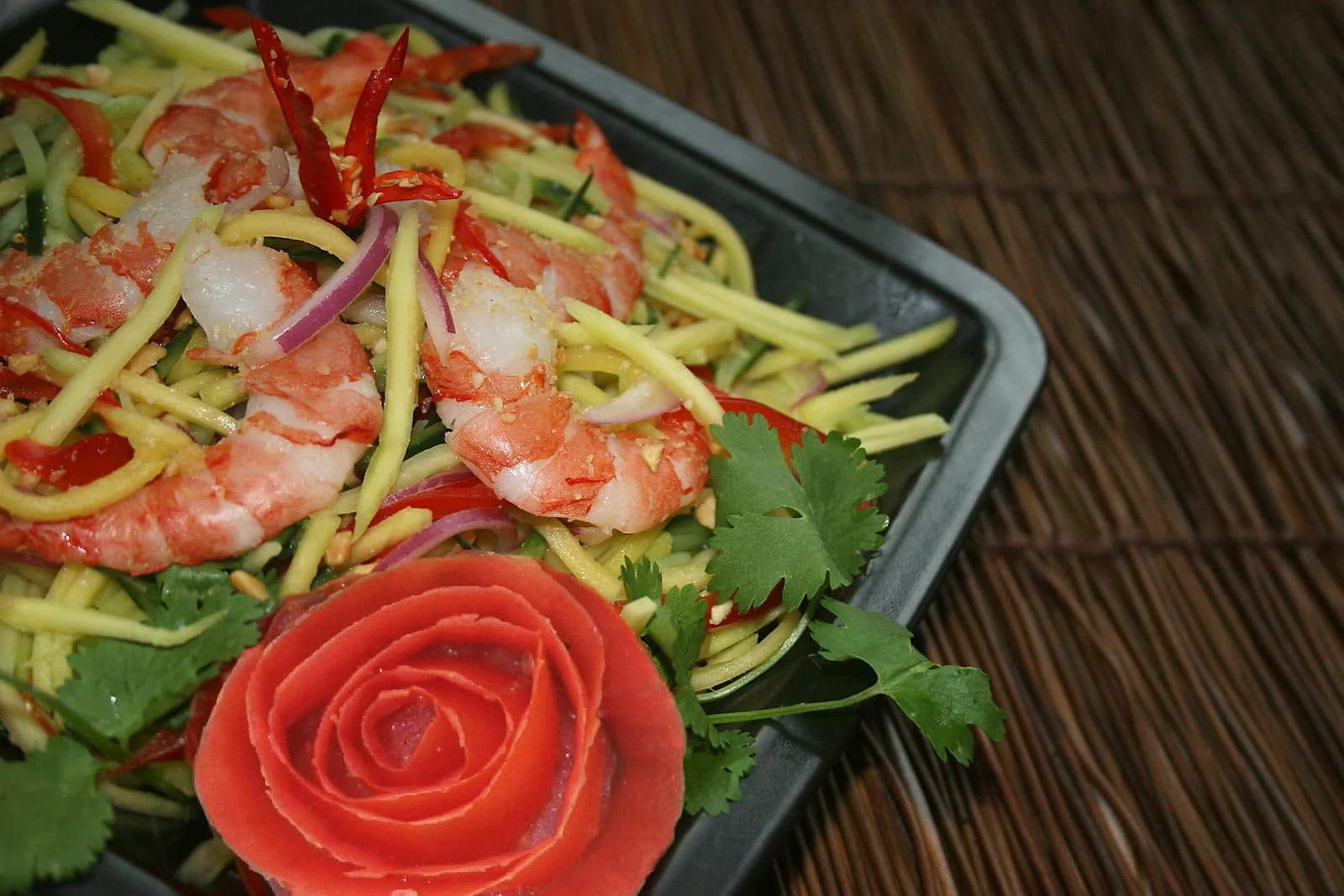 Mango salad with prawns, chilli and a carved tomato rose